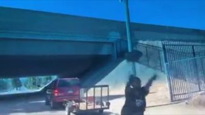 A man hurls a concrete block at a car after being confronted about illegal dumping in Pomona on Aug. 9, 2019. (Credit: Amos Young)