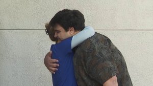 Ben Kadish hugs Cathy Carter, the nurse who helped save him after he was shot at the North Valley Jewish Community in Granada Hills on Aug. 10, 1999. They met outside the hospital where he was treated, Providence Holy Cross Medical Center in Mission Hills, on Aug. 7, 2019. (Credit: KTLA)