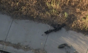 A weapon is seen on the ground following a shooting incident off the 215 Freeway near Box Springs Boulevard on Aug. 12, 2019. (Credit: KTLA)