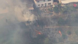 Firefighters beat back flames as they burned dangerously close to homes in Murrieta on Sept. 5, 2019. (Credit: KTLA)