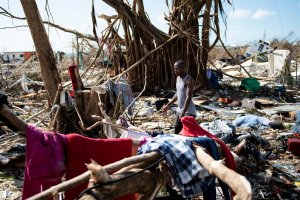 A man walks past damages caused by Hurricane Dorian on Sept. 5, 2019, in Marsh Harbour, Great Abaco Island in the Bahamas. (Credit: BRENDAN SMIALOWSKI/AFP/Getty Images)