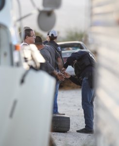 Investigators arrest two men during a raid at an illegal marijuana grow site in North Palm Springs on Sept. 19, 2019. (Credit: Riverside County District Attorney's Office)