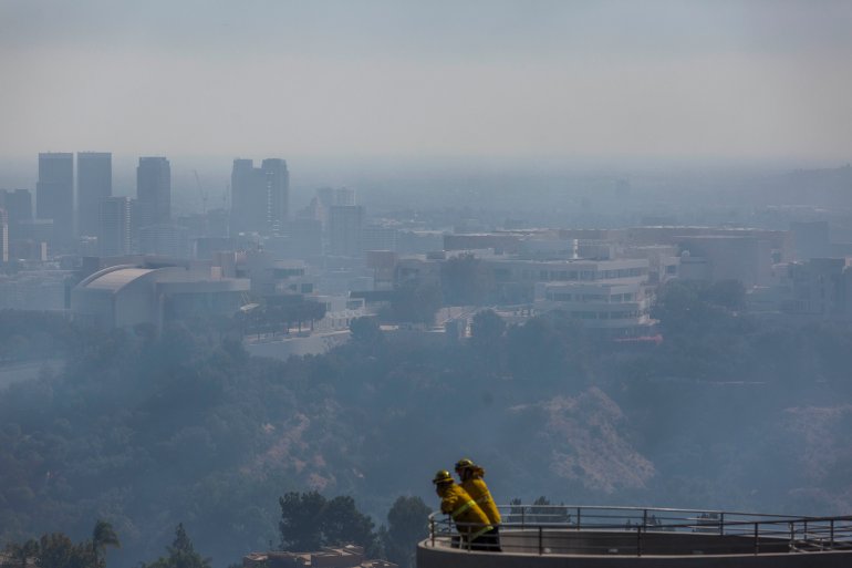 Firefighters stand on a balcony overlooking the Getty Center as the Getty Fire burns in Brentwood on Oct. 28, 2019. (Credit: Apu Gomes / AFP / Getty Images)