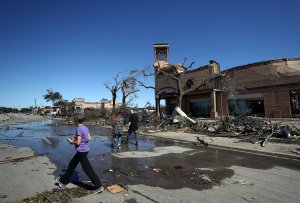 Local residents walk past a Gap store damaged by a tornado in the Preston Royal shopping area of Dallas on Oct. 21, 2019. (Credit: Ronald Martinez / Getty Images)