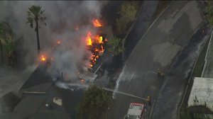 A home burns during a vegetation fire in San Bernardino on Oct. 21, 2019. (Credit: KTLA)