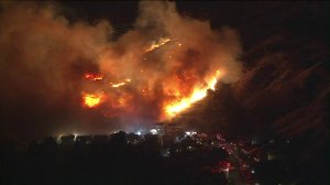 Firefighters battle a wildfire near homes in Sylmar on Oct. 10, 2019. (Credit: KTLA)