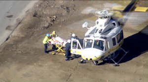 Rescuers work at the scene of a collision involving public works employees in the Santa Monica Mountains near Agoura Hills on Oct. 3, 2019. (Credit: KTLA)