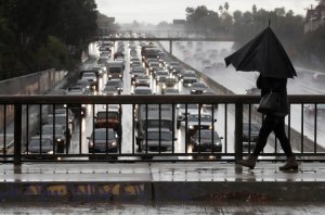 A pedestrian walks on an overpass as motorists clog the 101 Freeway during heavy rain in an undated photo. (Credit: Mel Melcon / Los Angeles Times)