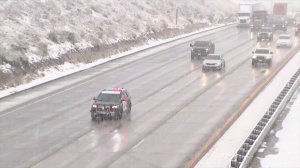 A CHP officer escorts traffic through the Grapevine amid a storm on Nov. 27, 2019. (Credit: KTLA)