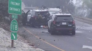 A heavily damaged Los Angeles police vehicle is seen behind a white Mercedes SUV that came to rest upside-down after crashing in Pacoima on Nov. 11, 2019. (Credit: KTLA)