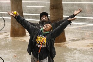 Tramell Waller and Keena Spencer welcome the rain and hail falling in downtown Los Angeles on Nov. 20, 2019. (Credit: Al Seib / Los Angeles Times)