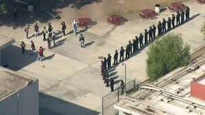 Police officers stand guard at John C. Fremont High School in the Florence neighborhood of the South L.A. area after multiple fights were reported at the campus on Nov. 12, 2019. (Credit: KTLA)