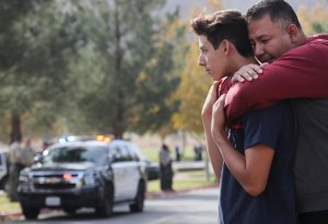 Marco Reynoso, right, hugs his son, 11th-grader Dylan Reynoso, after reuniting at a park near Saugus High School after a shooting left two students dead and three wounded on Nov. 14, 2019. (Credit: Mario Tama / Getty Images)