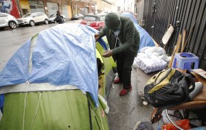 John Gunn looks into his tent on Skid Row after rain and hail soaked his belongings on Nov. 20, 2019. (Credit: Al Seib / Los Angeles Times)