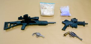 Guns and drugs seized at the Santa Ana home of Antonio Silva, a homicide and kidnapping suspect, are seen in a photo released Nov. 20, 2019, by the Anaheim Police Department.