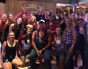 In this photo provided by family to CNN in November 2019, Justin Meek, center, poses with his sister, below right, and his friends at Borderline Bar & Grill in Thousand Oaks.