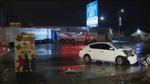 A heavily damaged sedan is seen near a big rig that had crashed into a liquor store in the North Hollywood area on Dec. 23, 2019. (Credit: KTLA)