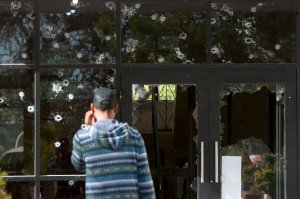 A man observes the shot-out facade of the a government building in Villa Union, Coahuila state, Mexico, on Dec. 2, 2019. (Credit: Julio Cesar Aguilar / AFP / Getty Images)