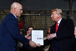 President Donald Trump, right, hands General John W. Raymond a document after signing the National Defense Authorization Act at Joint Base Andrews, Maryland, on Dec. 20, 2019. (Credit: Nicholas Kamm / AFP / Getty Images)