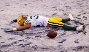 Aaron Jones #33 of the Green Bay Packers makes a snow angel in the end zone in the fourth quarter against the New York Giants at MetLife Stadium on Dec. 1, 2019 in East Rutherford, New Jersey. (Credit: Elsa/Getty Images)