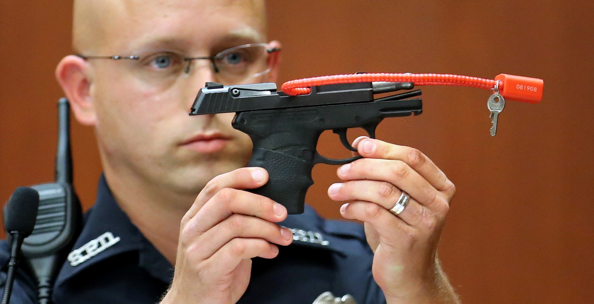 Sanford police officer Timothy Smith holds up the gun that was used to kill Trayvon Martin, while testifying in the 15th day of the George Zimmerman trial, in Seminole circuit court in Sanford, Fla., Friday, June 28, 2013. Zimmerman is accused in the fatal shooting of Trayvon Martin. Photo credit: Joe Burbank/POOL