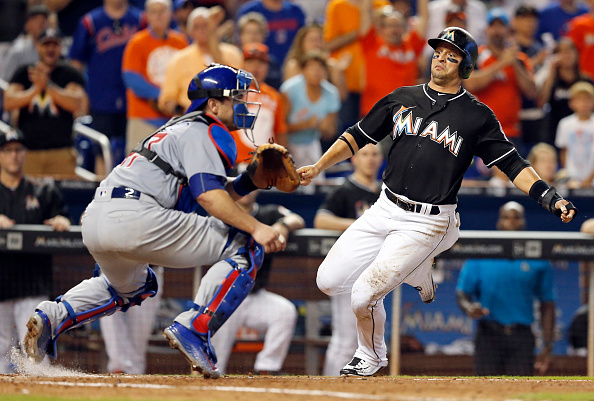 The Miami Marlins' Martin Prado scores behind Chicago Cubs catcher Miguel Montero in the fifth inning on a single by Giancarlo Stanton at Marlins Park in Miami on Saturday, June 25, 2016. The Marlins won, 9-6. (Al Diaz/Miami Herald/TNS via Getty Images)