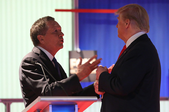 Republican presidential candidates (L-R) Ohio Governor John Kasich and Donald Trump talk during a commercial break during the Fox Business Network Republican presidential debate at the North Charleston Coliseum and Performing Arts Center on January 14, 2016 in North Charleston, South Carolina. (Photo by Scott Olson/Getty Images)