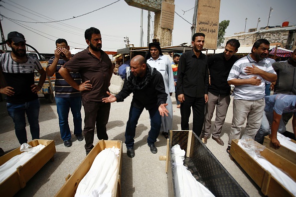 Iraqi men mourn over bodies after they lost five members of their family in a suicide bombing that ripped through Baghdad's busy shopping district of Karrada, during their funeral in the holy Iraqi city of Najaf on July 3, 2016. The blast hit the Karrada district early in the day as the area was packed with shoppers ahead of this week's holiday marking the end of the Muslim fasting month of Ramadan, killing at least 75 people in the deadliest single attack this year in Iraq's capital. / AFP / Haidar HAMDANI (Photo credit should read HAIDAR HAMDANI/AFP/Getty Images)