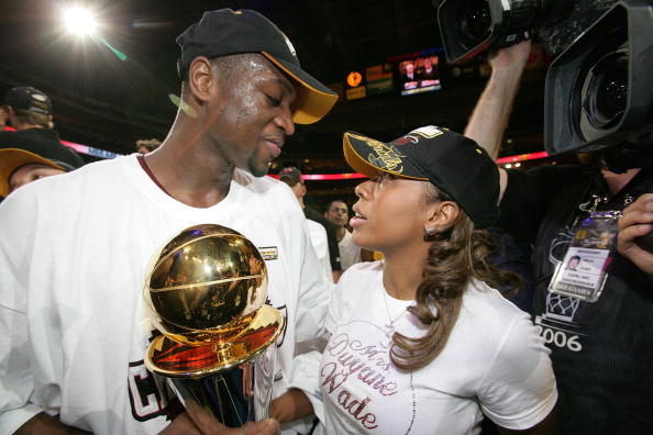 Finals MVP Dwyane Wade #3 of the Miami Heat celebrates with his wife Siohvaughn Wade and the MVP trophy as he walks off the court after the Heat beat the Dallas Mavericks 95-92 in Game Six of the 2006 NBA Finals June 20, 2006 at American Airlines Center in Dallas, Texas. (Photo by Victor Baldizon/NBAE/Getty Images)