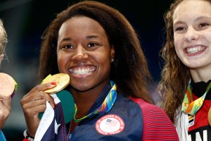 RIO DE JANEIRO, BRAZIL - AUGUST 11: Gold medalist Simone Manuel of the United States celebrates during the medal ceremony for the Women's 100m Freestyle Final on Day 6 of the Rio 2016 Olympic Games at the Olympic Aquatics Stadium on August 11, 2016 in Rio de Janeiro, Brazil. (Photo by Clive Rose/Getty Images)