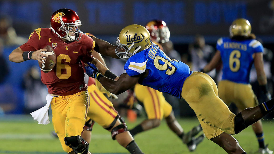 UCLA's Owamagbe Odighizuwa rushes USC's Cody Kesler. (Luis Sinco / Los Angeles Times)