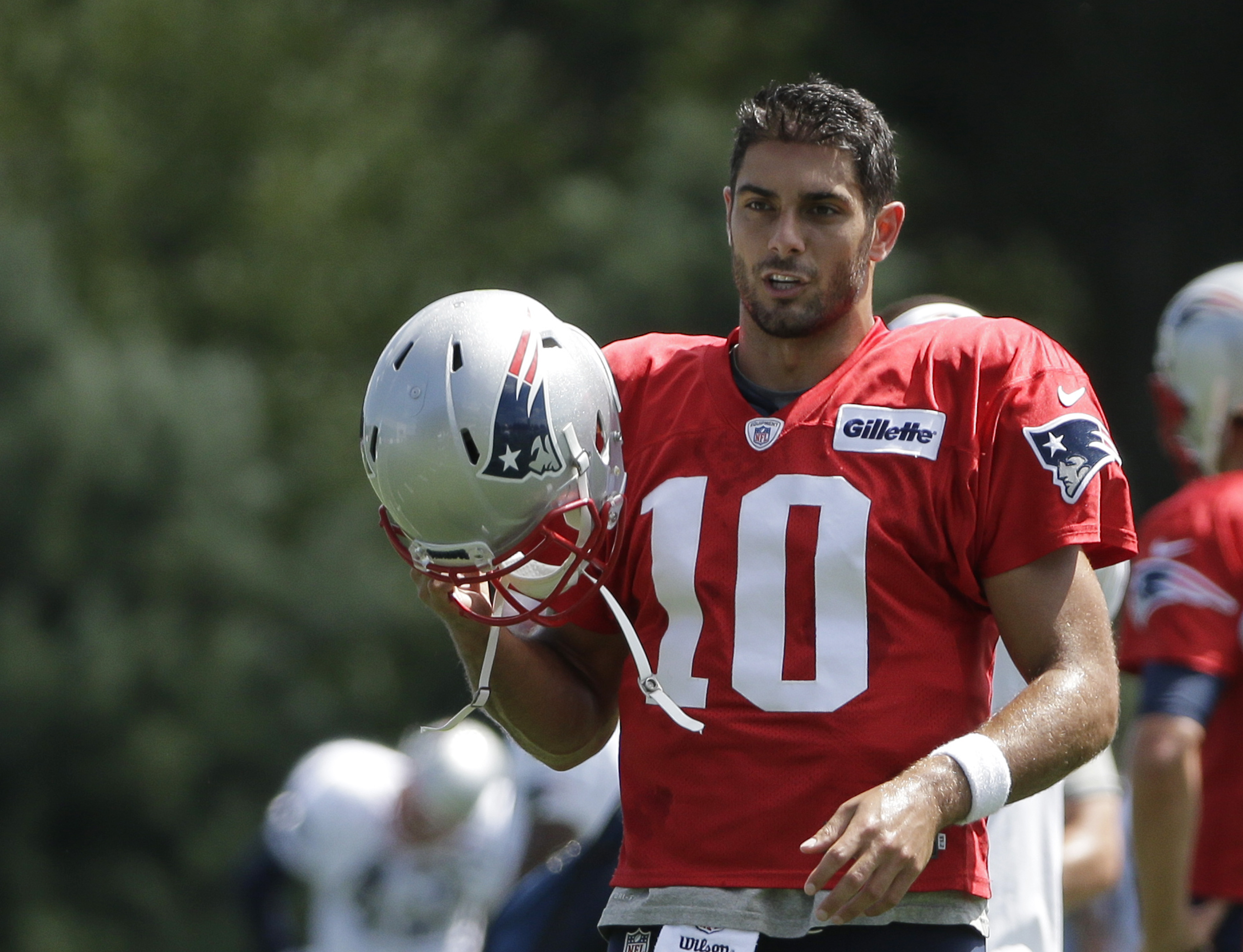 New England Patriots quarterback Jimmy Garoppolo removes his helmet during an NFL football training camp practice with the Chicago Bears. (AP Photo/Steven Senne)