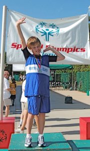 Inspiring an athlete -- Here, a 12-year-old John shows off his first-place medal for the 100 meters at the Special Olympics Summer State Games in 2008.