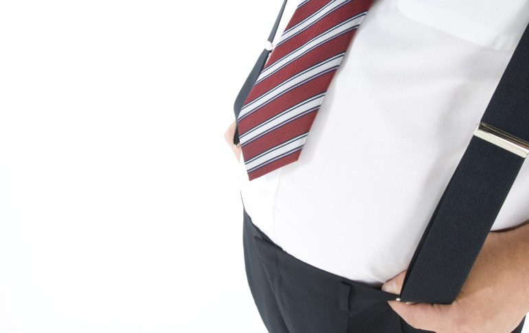 Overweight businessman with a pot belly holding his suspenders