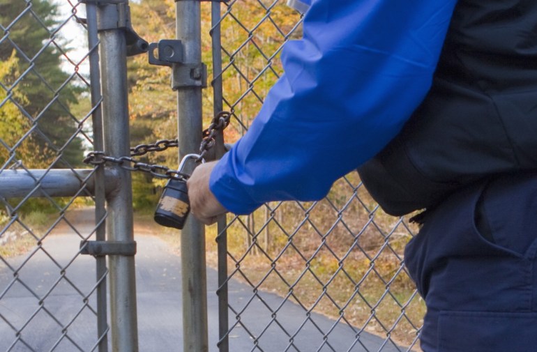 Security guard locking a gate at water treatment facility
